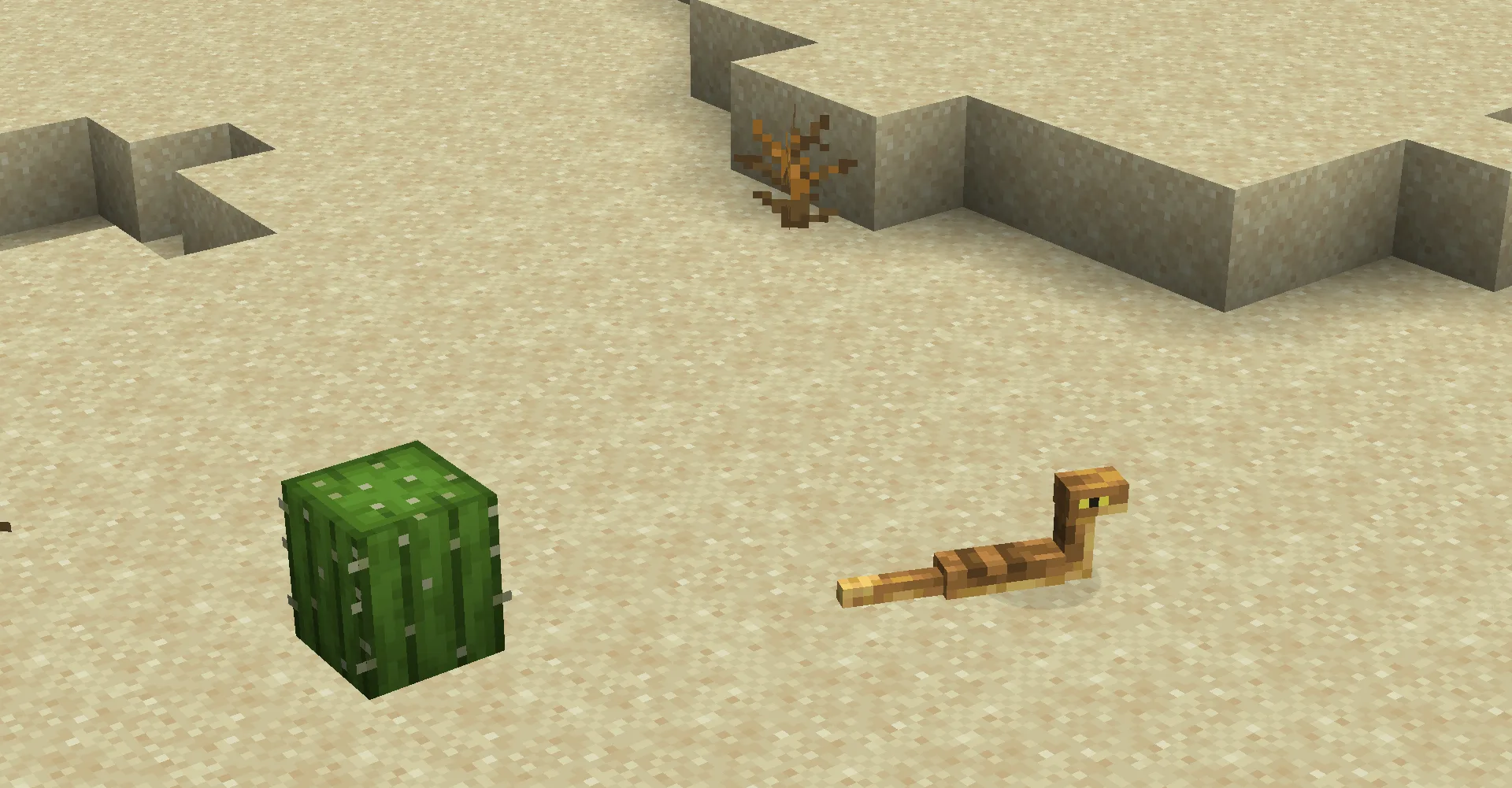 Гремучая змея ползет по песку в пустыне рядом с кактусом.