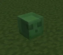 Зеленый кубический слизень из Minecraft на траве.